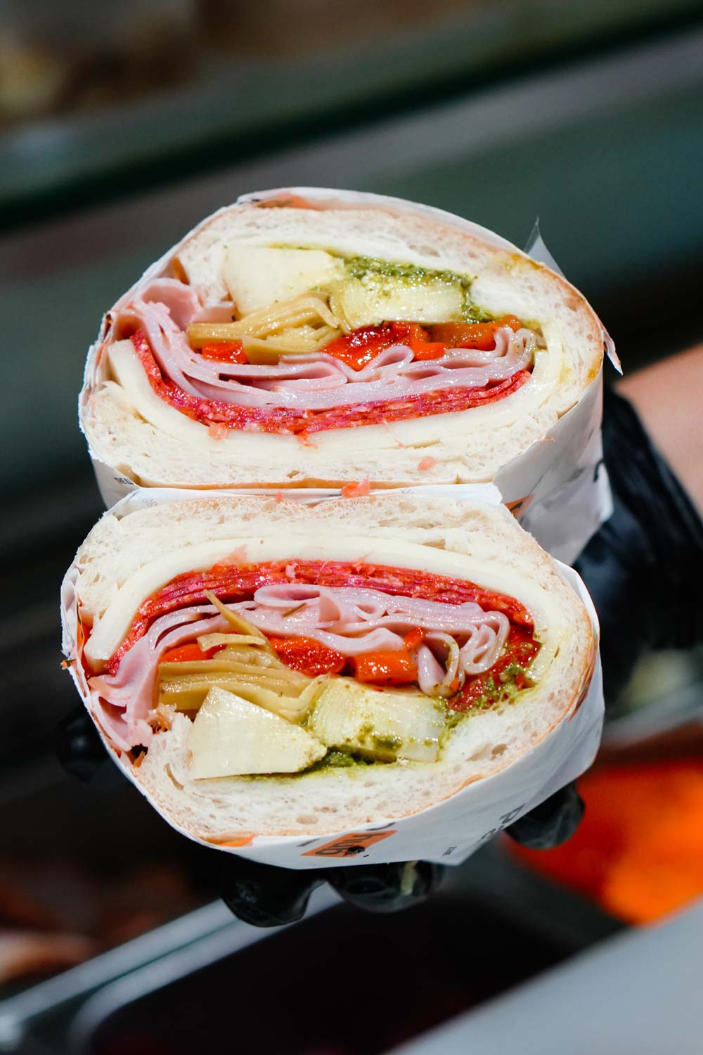 A freshly-made panini with colourful ingredients cut in half with the middles exposed