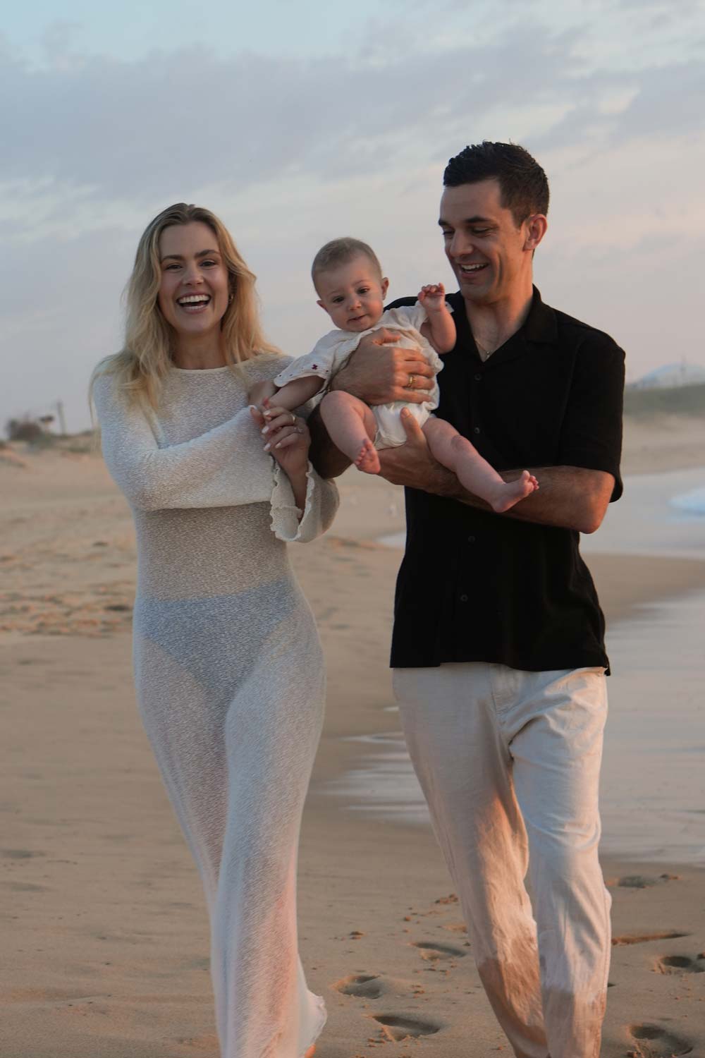 A happy family of three walking along a sandy beach or a morning