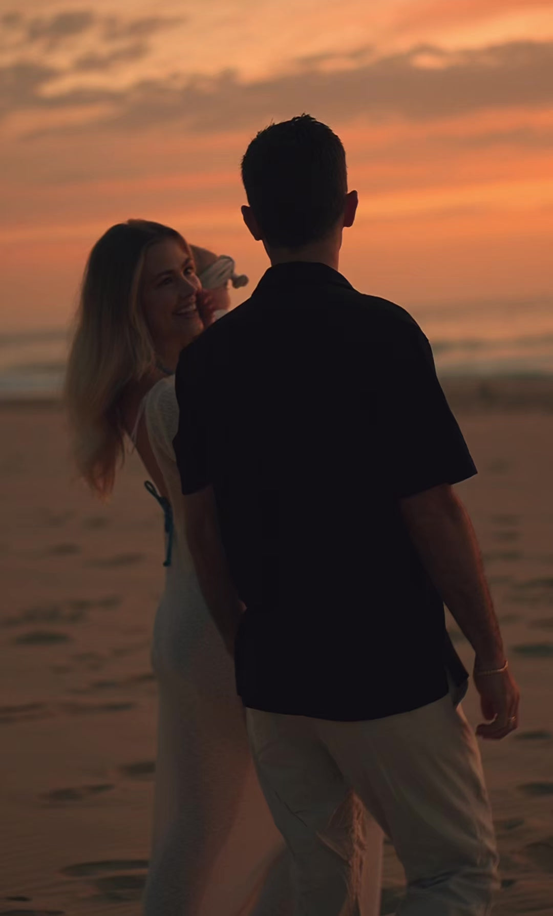 Load video: Video of a young family on a sandy beach during a sunrise