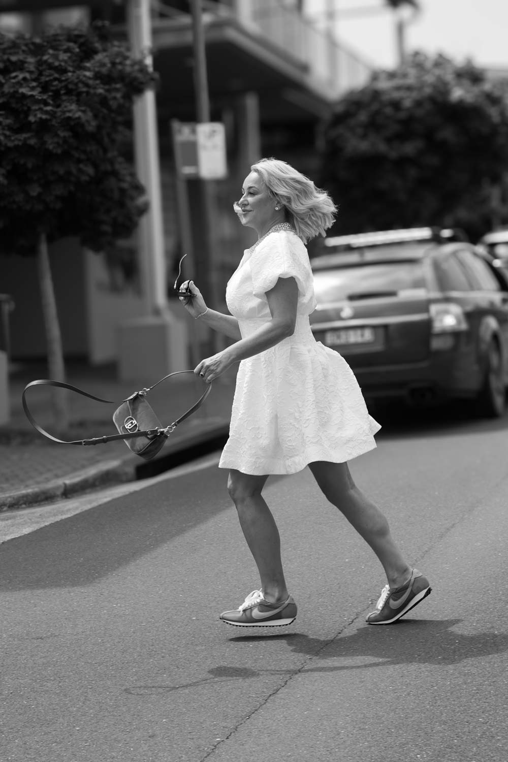 Lady in a white dress crossing a road